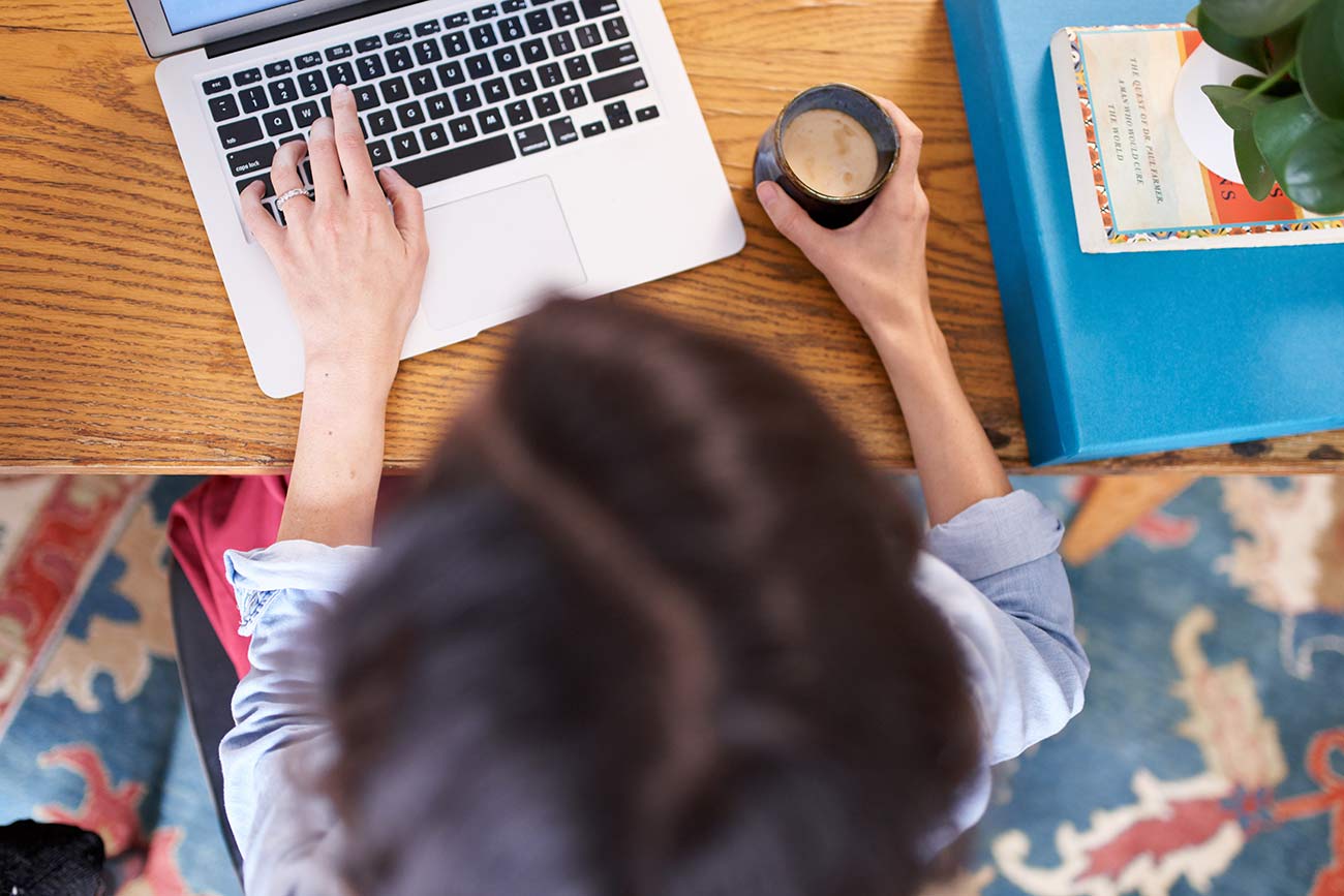 Copywriter from above working on laptop